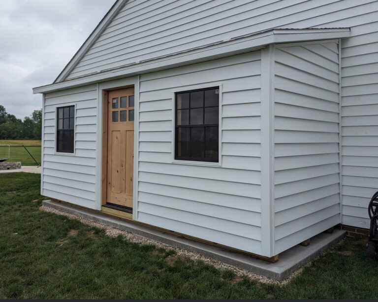 Side profile of a Modern Studio storage shed with white vinyl siding