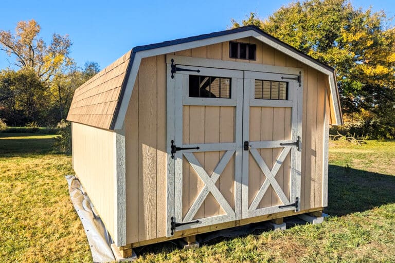 One of our peach and white wood mini barn sheds in Gahanna OH - Peach siding with white-trimmed double doors and corners under brown shingled gambrel-style roof