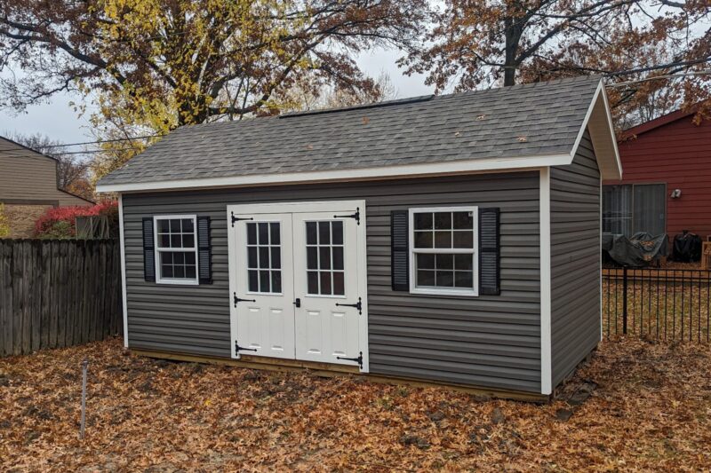 One of our gray and white Cape Cod sheds for sale in Lincoln Village OH - Gray siding with white double doors and white-trimmed windows with black shutters