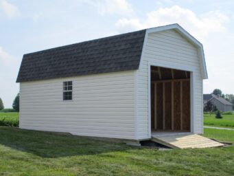 One of our white highwall garage sheds in Urbana OH - White siding with side window and open overhead door beneath dark gray shingled roof